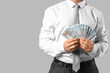 © Pixel-Shot - Businessman with money on grey background, closeup