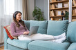 © Srdjan - Young woman former victim of domestic violence relax in her apartment has a video call on laptop computer explain and talk about how to reclaim life and have strength to let go of toxic relationships.