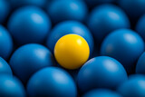 One yellow sphere among many blue spheres a unique contrast