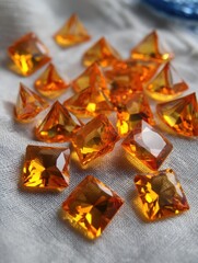 Poster - Gleaming Amber Gems on Soft Fabric A Captivating Still Life of Faceted Beauty and Warm Tones for Jewelry Design and Precious Stone Concepts