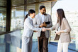 © BGStock72 - Business professionals engage in a friendly handshake on a sunny day in a modern office building