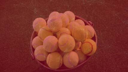 Poster - Metal bucket filled with tennis balls resting on dark court, showing red digital mesh overlay