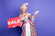 © deagreez - Elegant woman in historical attire showcasing a sale promotion against purple background