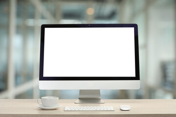 Aufkleber - Computer monitor with blank screen and cup on wooden desk against blurred background. Mockup for design