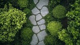 Stone pathway winds through lush green bushes in an outdoor garden setting.