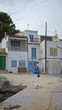 © Krakenimages.com - Woman walking in old town featuring mediterranean architecture on mallorca coast with charming buildings in the background, capturing a blend of history and scenic beauty.