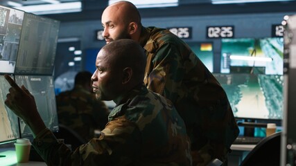 Poster - Air force officers performing tactical level reconnaissance in command post, looking at monitors. Military soldiers using radar devices to look at assault zones on displays, camera A