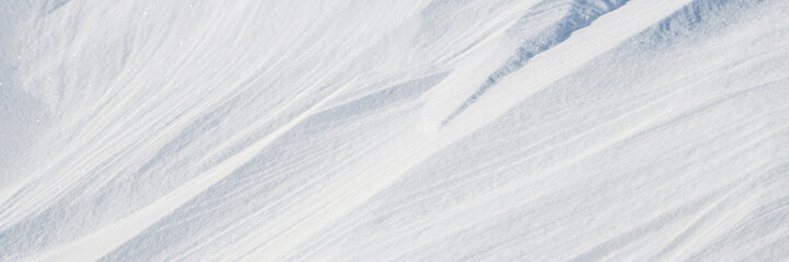 Wall Mural - beautiful winter background with snowy ground. natural snow texture. wind sculpted patterns on snow 