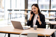 © David - Happy young business woman manager talking consulting client on cell phone working on laptop in office. Busy woman professional business making call on cell using computer sitting at desk