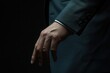 © Abdul - Elegant hand of a businessman in a suit, poised in a dark setting, suggesting confidence