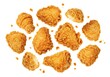 © Vooglo.com - Golden brown fried chicken pieces scattered on a white surface with crispy breading and small crumbs around them