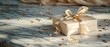 © Gadis - Beige gift box with ribbon on marble surface, golden confetti and fabric in background