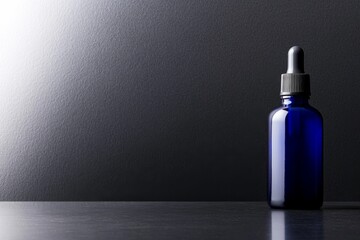 Leinwandbilder - Sleek cobalt blue serum bottle with dropper placed on a reflective black surface, accentuated by soft lighting and ample blank space for creative text