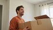 © deFusum - Smiling Man Holding Cardboard Boxes Indoors