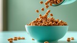 Teal bowl filled with square-shaped pet food kibble pou from a glass jar against a muted green background creating a serene feeding scene for pets