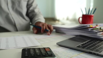 Poster - businessman uses a calculator and paperwork to analyze finances, investments, and tax reports at his desk calculator and digital tablet. business financial reports and data analysis				