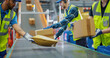 © Gorodenkoff - In a Modern Sorting Center Facility, Diverse Workers in Safety Vests Loading Parcels Onto a Conveyor, Efficiently Working Together as a Team. Logistics and Postal Service Operations