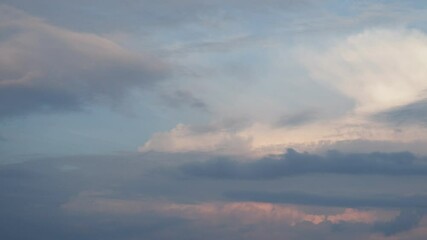 Poster - Pink, yellow, grey and blue clouds. As day transitions to night, wispy clouds and steam dance across the sky, reflecting the warm hues of the sunset.  Tranquil evening atmosphere. Real time motion.