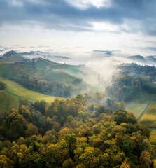 Wall Mural - aerial landscape with fluffy morning mists over the picturesque, autumn-covered rolling hills near m