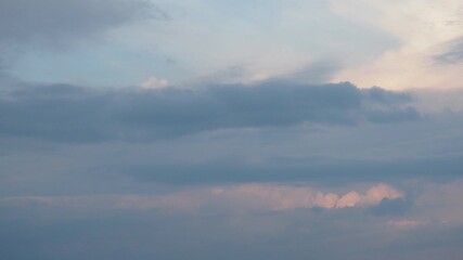 Poster - Pink, yellow, grey and blue clouds. As day transitions to night, wispy clouds and steam dance across the sky, reflecting the warm hues of the sunset.  Tranquil evening atmosphere. Real time motion.