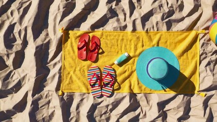 Poster - Vibrant summer scene unfolding with colorful beach accessories gradually appearing on yellow beach towel resting across sandy surface, showcasing vacation preparation and anticipation
