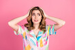 © deagreez - Young woman with wavy brown hair wearing a colorful printed shirt, thoughtfully posing against a vibrant pink background in a casual style