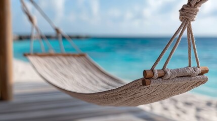 Aufkleber - White beach hammock is hanging over the ocean. The hammock is tied to a wooden post. The ocean is calm and blue