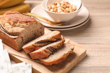 Wall Mural - pieces of banana bread with nuts on wooden table, closeup