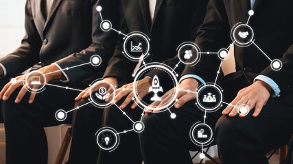 Poster - Group of business professionals in suits engaged in a meeting, surrounded by digital icons representing various concepts such as innovation, strategy, and finance, emphasizing teamwork. Amity