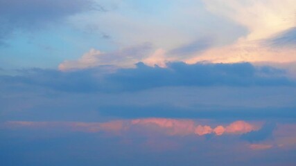 Poster - Pink, yellow, grey and blue clouds. As day transitions to night, wispy clouds and steam dance across the sky, reflecting the warm hues of the sunset.  Tranquil evening atmosphere. Real time motion.