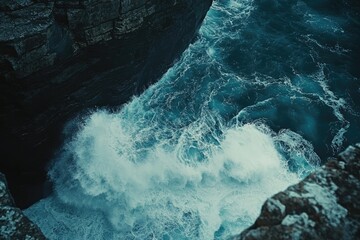 Aufkleber - Ocean waves crashing against dark rocky cliffs, creating a dramatic and powerful scene.