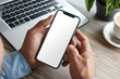 © Deris Firmansyah - Latin indian adult student holding using mock up of cell mobile smartphone with empty blank white screen for advertising. Over shoulder closeup view.