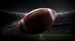 © Kenio - Close up of an american football in motion with a stadium background at night under dramatic lighting