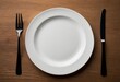 © 薛海梅 薛海梅 - A white plate with a fork and knife was placed on the table