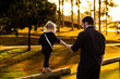 © Austockphoto - Child showing trust walking along post holding to fathers hand in golden light