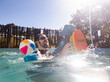 © Austockphoto - Young dad with toddler child playing in backyard pool together splashing in water with sun flare