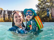 © Austockphoto - Happy Australian mum with toddler daughter playing together while swimming in backyard pool