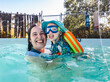 © Austockphoto - Happy Australian mum with toddler daughter playing together while swimming in backyard pool