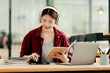 © Daenin - Beautiful Asian female student studying online and taking notes Female accountant makes annual financial and tax reports.