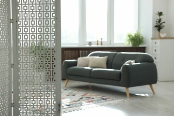 Aufkleber - Comfortable sofa and folding screen indoors, selective focus. Interior design