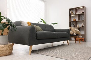Aufkleber - Stylish living room with comfortable sofa and wooden shelving unit. Interior design