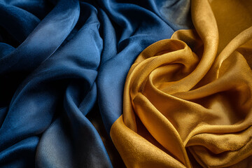 Poster - Dark blue and gold silk fabric texture, draped in soft folds, showcasing luxurious and elegant design, ideal for background or banner