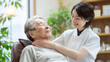 © NIPAPORN - Caring nurse assisting elderly woman with warm smile in cozy setting