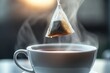 © Marina Demidiuk - Teabag above a white ceramic mug with a steaming drink. Hand is picking a tea bag into a cup of tea. Teabag in hot water. Morning beverage. Tagged teabags with string. Someone preparing tea. Warm
