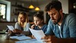 © fatah - Family stressed over bills.  Concerned parents and child reviewing financial documents at a kitchen table