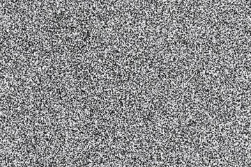Fototapete - Abstract grayscale texture of granular particles.  A complex, mottled pattern of light and dark specks creates a dense, uneven surface