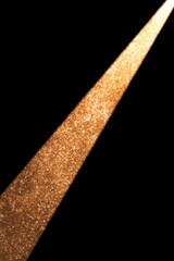 Wall Mural - golden spotlight illuminating dark room with falling particles