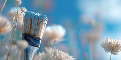 Poster - Close-up of paintbrush with light blue paint, against blurred white flowers and blue background, suggesting creativity and artistry