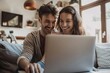 © Deris Firmansyah - Happy mature mid age couple using laptop sit on sofa doing ecommerce shopping online on website. Smiling senior old adult man and woman looking at computer buying insurance browsing internet at home.