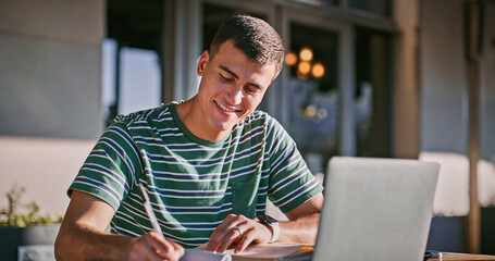 Fototapete - Man, university student and happy with laptop or writing on notebook for assignment on campus. Male person, college learner and textbook for education with research or study for exam and assessment